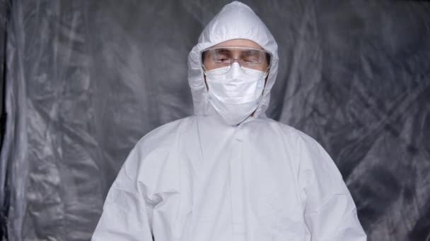 Lekarz w białym kombinezonie ochronnym, masce medycznej i gumowych rękawiczkach trzyma czerwoną pigułkę jako lekarstwo na pandemię koronawirusową. Epidemia, pandemia koronawirusa covid 19. — Wideo stockowe