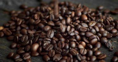 Ahşap bir masaya saçılmış kavrulmuş Arap kahve çekirdekleri. Taze kahve çekirdekleri. Espresso, americano, doppio, cappuccino, latte. Robusta. Seçici odak.