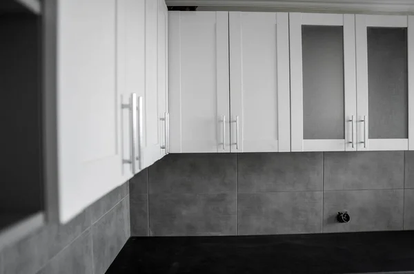 Установка кухонних шаф на замовлення з білими фасадами меблів mdf. Сіра модульна кухня з матеріалу ДСП на різних етапах установки. Рамка меблеві фасади профілю Mdf . — стокове фото