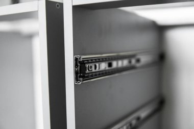 Paslanmaz teleskopik süngü çekmecesi kaydırak rehberleri, gri yonga masasından mutfak dolabına monte edilmiş. Mobilya yapımında kullanılan marangozluk aksesuarları. Özel mutfak kurulumu.