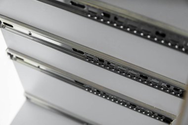 Paslanmaz teleskopik süngü çekmecesi kaydırak rehberleri, gri yonga masasından mutfak dolabına monte edilmiş. Mobilya yapımında kullanılan marangozluk aksesuarları. Özel mutfak kurulumu.