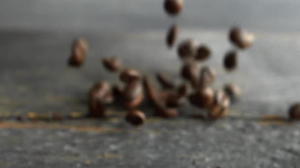 Свежий жареный кофе в зернах падает на деревянный стол. Свежий жареный кофе в Арабика бобы готов для шлифования и сделать вкусный кофе. — стоковое видео