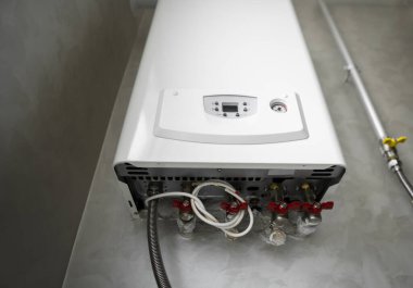 Mutfakta gri bir duvara monte edilmiş beyaz, modern ev gazı kazanı. Su ısıtıcısı. Su ısıtma, ekoloji..