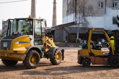 LUTSK, UKRAINE - 10 Mayıs 2020: Yellow wheel loader Excavator machine kereste fabrikasında çalışıyor.