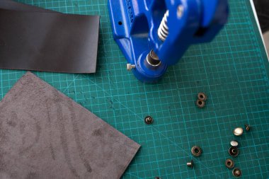 Zanaatkârlar cüzdan yapmak için deri mandalları kullanırlar. El Baskısı Baskı Makinesi deri atölyesinde zanaatkar tarafından kullanılıyor..