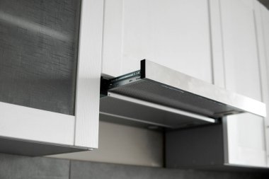 Modern beyaz minimalist mutfağın üzerinde gri paslanmaz cam kaput. Mutfak malzemeleri..