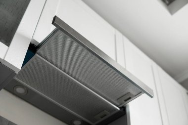 Modern beyaz minimalist mutfağın üzerinde gri paslanmaz cam kaput. Mutfak malzemeleri..