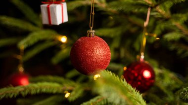 Işıklar ve kırmızı oyuncaklarla süslenmiş Noel ağacı.