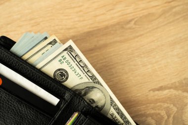 Tahta bir masaüstü, çevrimiçi ödeme sistemleri ve bankacılık konsepti üzerinde kredi kartı ve nakit para ile dizüstü bilgisayar ve cüzdan.