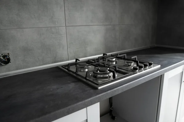 Ανοξείδωτη γκρι μεταλλική κουζίνα γκαζιού τοποθετημένη σε κουζίνα με σκούρο γκρι τραπέζι. — Φωτογραφία Αρχείου