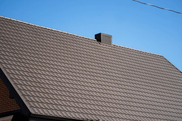 Telhado de perfil de metal ondulado marrom instalado em uma casa moderna. O telhado de chapa ondulada. Telhado de metal perfil ondulado forma. Telhado moderno feito de metal. Cobertura metálica. — Fotografia de Stock