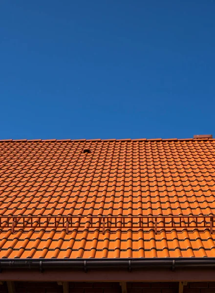 現代の家に設置された赤い段ボール金属プロファイルの屋根。段ボールシートの屋根。金属プロファイル波状形状の屋根。金属製の近代的な屋根。金属屋根. — ストック写真