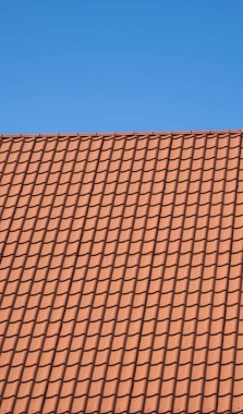 Modern bir evin çatısına kırmızı kıvrımlı metal profil çatısı döşenmiş. Çürük çarşafın çatısı. Metal profil dalgalı şeklinin çatısı. Metalden yapılmış modern çatı. Metal çatı..