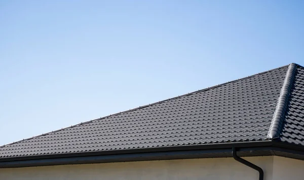 Telhado de perfil de metal ondulado marrom instalado em uma casa moderna. O telhado de chapa ondulada. Telhado de metal perfil ondulado forma. Telhado moderno feito de metal. Cobertura metálica. — Fotografia de Stock