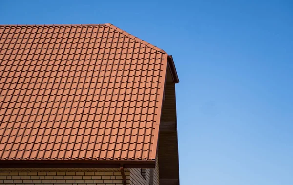 现代房屋上安装的红色波纹金属结构屋顶.瓦楞纸的屋顶。金属表面波浪形屋顶.现代的屋顶是金属做的.金属屋顶. — 图库照片