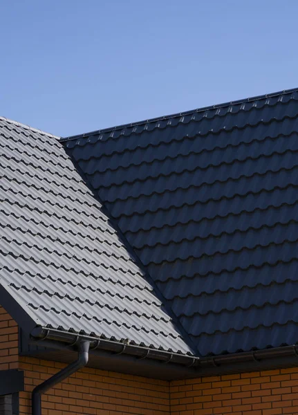 Szary dach z blachy falistej zainstalowany na nowoczesnym domu. Dach z blachy falistej. Pokrycie dachu metalowym profilem falistego kształtu. Nowoczesny dach wykonany z metalu. Dachy metalowe. — Zdjęcie stockowe