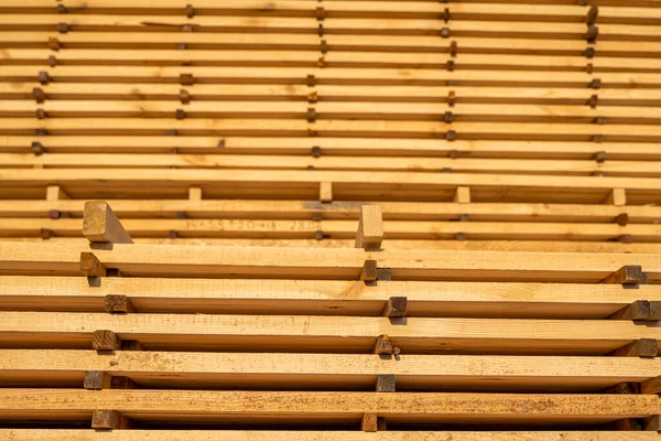 Armazenamento de pilhas de tábuas de madeira na serraria. As tábuas estão empilhadas numa carpintaria. Serragem de secagem e comercialização de madeira. Pinheiro para a produção de móveis, construção. Indústria madeireira. — Fotografia de Stock