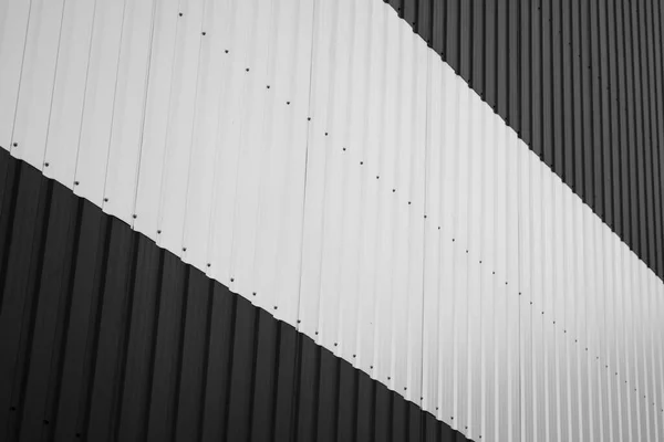 Feuille de fer ondulé noir et blanc utilisée comme façade d'un entrepôt ou d'une usine. Texture d'une façade en aluminium ondulé sans soudure en tôle de zinc. L'architecture. Texture métallique. — Photo