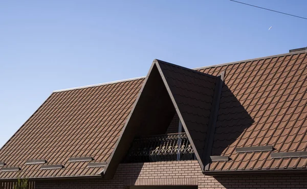 Brown corrugated metal profile roof installed on a modern house. The roof of corrugated sheet. Roofing of metal profile wavy shape. Modern roof made of metal. Metal roofing. — Stock Photo, Image