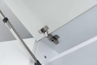 Mutfak dolabına beyaz bir yonga tahtasından yerleştirilmiş metal bir döngü..