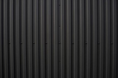 Black corrugated iron sheet used as a facade of a warehouse or factory. Texture of a seamless corrugated zinc sheet metal aluminum facade. Architecture. Metal texture. clipart