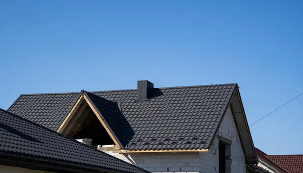 Braunes Wellblechprofildach, das auf einem modernen Haus installiert wurde. Das Dach aus Wellblech. Überdachung von Metallprofilwellenform. Modernes Dach aus Metall. Metalldächer. — Stockfoto