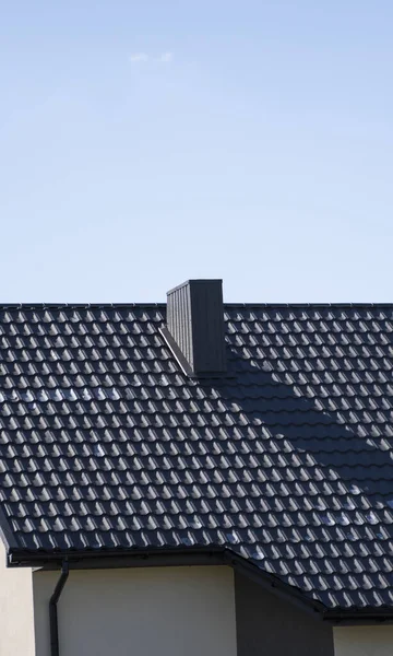 Коричневая гофрированная металлическая крыша, установленная на современном доме. Крыша из гофрированного листа. Крыша металлического профиля волнистой формы. Современная крыша из металла. Металлическая кровля. — стоковое фото