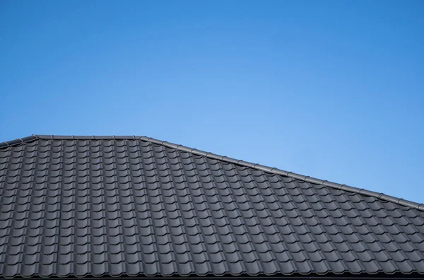 갈색 주름진 금속 프로파일 지붕 이 현대 주택에 설치되어 있다. 골함석의 지붕. 금속 프로파일의 뿌리 모양이 뒤엉켜 있다. 현대의 지붕은 금속으로 만들어 졌다. 금속 지붕. — 스톡 사진