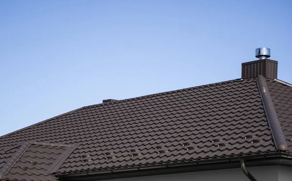 Brązowy dach z blachy falistej zainstalowany na nowoczesnym domu. Dach z blachy falistej. Pokrycie dachu metalowym profilem falistego kształtu. Nowoczesny dach wykonany z metalu. Dachy metalowe. — Zdjęcie stockowe