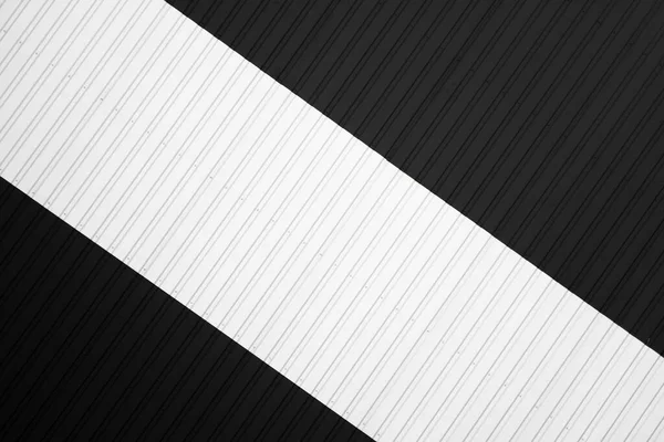 Czarno-biała blacha falista stosowana jako fasada magazynu lub fabryki. Tekstura bezszwowej falistej blachy cynkowej fasady aluminiowej. Architektura. Tekstura metalu. — Zdjęcie stockowe