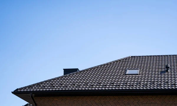 Bruin gegolfd metalen profieldak geïnstalleerd op een modern huis. Het dak van golfplaten. Dakbedekking van metalen profiel golvende vorm. Modern dak van metaal. Metalen dakbedekking. — Stockfoto