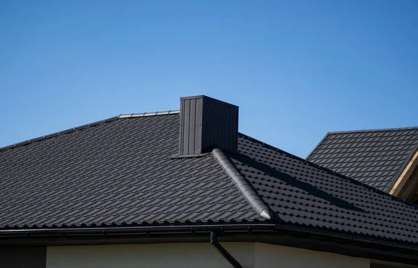 Braunes Wellblechprofildach, das auf einem modernen Haus installiert wurde. Das Dach aus Wellblech. Überdachung von Metallprofilwellenform. Modernes Dach aus Metall. Metalldächer. — Stockfoto