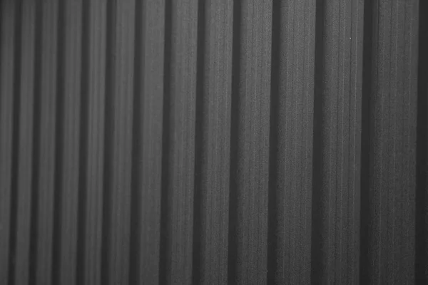 Schwarzes Wellblech, das als Fassade eines Lagers oder einer Fabrik verwendet wird. Textur einer nahtlosen Wellblechfassade aus Aluminium. Architektur. Metallstruktur. — Stockfoto