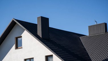 Modern bir eve konmuş gri çatılı metal profil çatısı. Çürük çarşafın çatısı. Metal profil dalgalı şeklinin çatısı. Metalden yapılmış modern çatı. Metal çatı..