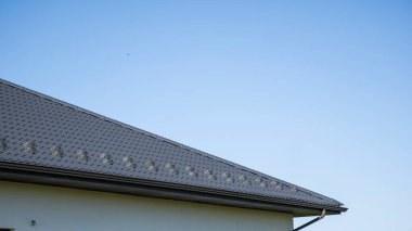 Modern bir eve konmuş gri çatılı metal profil çatısı. Çürük çarşafın çatısı. Metal profil dalgalı şeklinin çatısı. Metalden yapılmış modern çatı. Metal çatı..