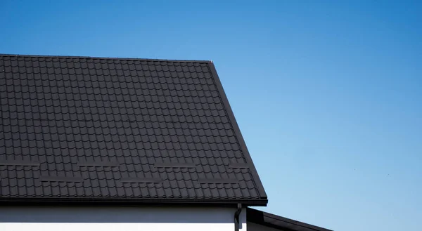 Barna hullámos fém profil tető telepítve egy modern házban. A hullámlemez teteje. Tetőfedő fém profil hullámos alakú. Modern tető fémből. Fémtetők. — Stock Fotó