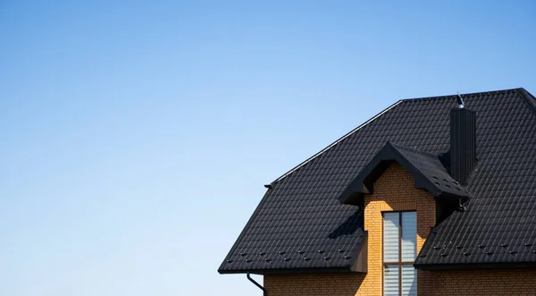 Çatı penceresi olan modern bir eve kahverengi çatılı metal profil çatısı. Çürük çarşafın çatısı. Metal profil dalgalı şeklinin çatısı. Metalden yapılmış modern çatı. Metal çatı.. — Stok fotoğraf