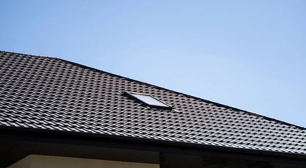 Hnědá vlnitá kovová střecha instalovaná na moderním domě. Střecha z vlnitého plechu. Střešní krytina kovového profilu vlnitého tvaru. Moderní střecha z kovu. Kovová střecha. — Stock fotografie
