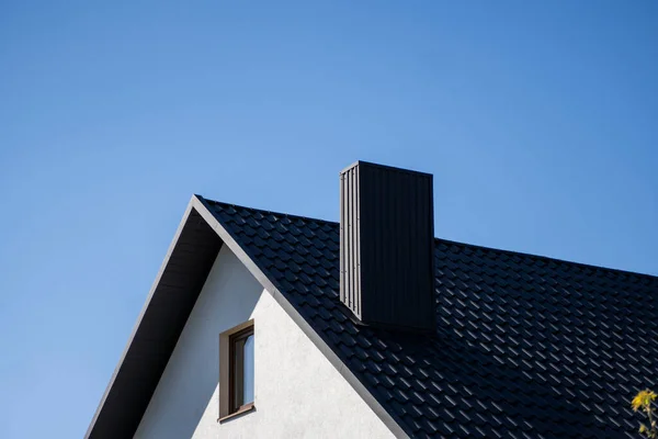 Grått profiltak i korrugerad metall monterat på ett modernt hus. Taket på wellpapp. Takläggning av metallprofil vågig form. Modernt tak av metall. Takläggning av metall. — Stockfoto