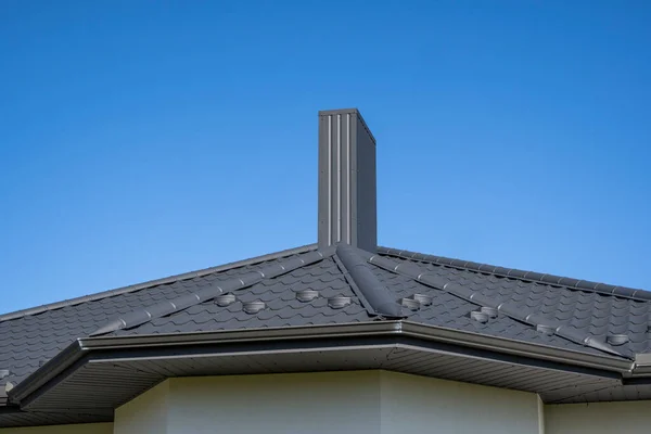 Серая гофрированная металлическая крыша, установленная на современном доме. Крыша из гофрированного листа. Крыша металлического профиля волнистой формы. Современная крыша из металла. Металлическая кровля. — стоковое фото