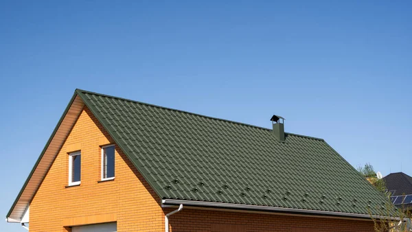 Groene golf metalen profiel dak geïnstalleerd op een modern huis. Het dak van golfplaten. Dakbedekking van metalen profiel golvende vorm. Modern dak van metaal. Metalen dakbedekking. — Stockfoto