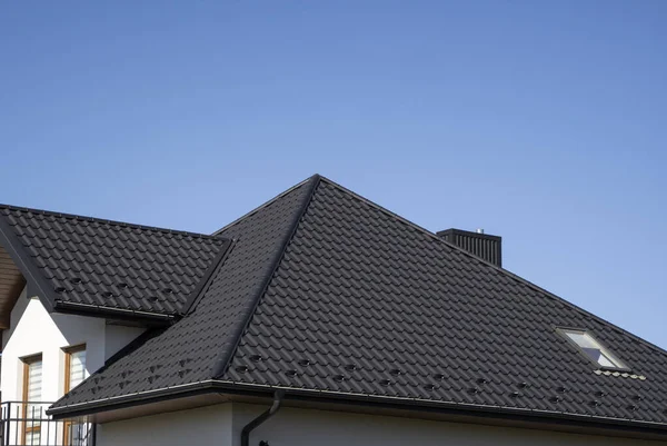 Bruin gegolfd metalen profieldak geïnstalleerd op een modern huis. Het dak van golfplaten. Dakbedekking van metalen profiel golvende vorm. Modern dak van metaal. Metalen dakbedekking. — Stockfoto