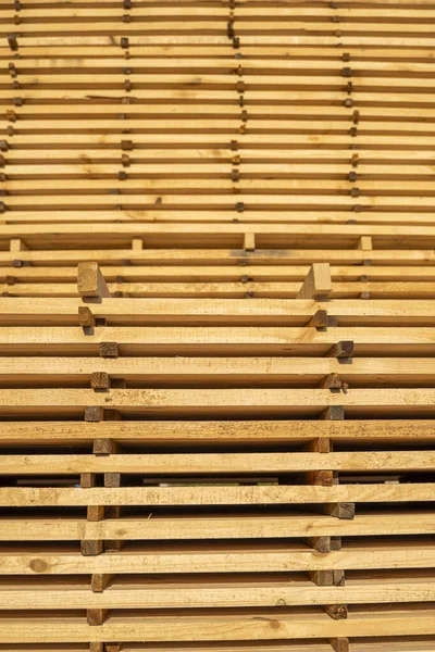 Storage of piles of wooden boards on the sawmill. Boards are stacked in a carpentry shop. Sawing drying and marketing of wood. Pine lumber for furniture production, construction. Lumber Industry. — Stock Photo, Image