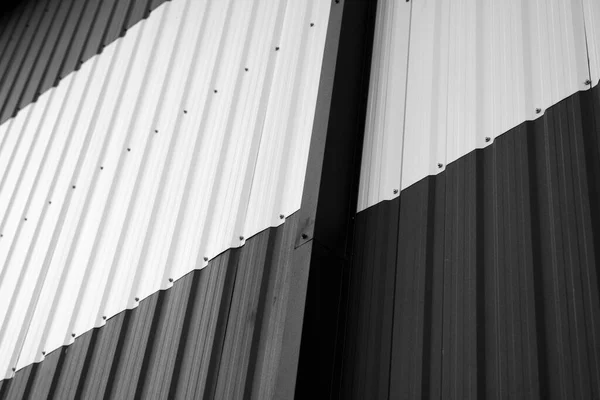 Détails de tôle ondulée noire et blanche utilisée comme façade d'un entrepôt ou d'une usine. Texture d'une façade en aluminium ondulé sans soudure en tôle de zinc. L'architecture. Texture métallique. — Photo