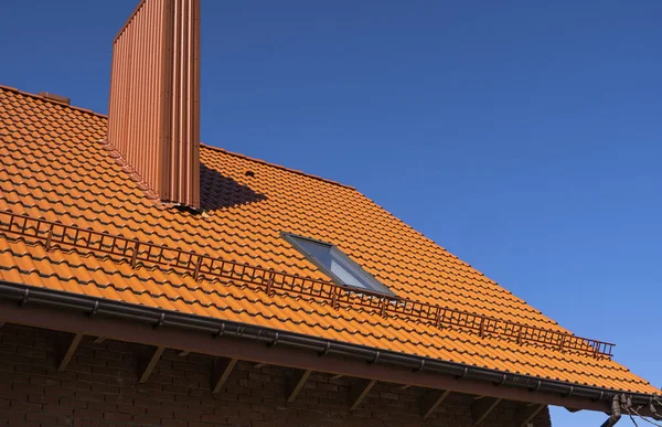 Rood gegolfd metalen profieldak geïnstalleerd op een modern huis. Het dak van golfplaten. Dakbedekking van metalen profiel golvende vorm. Modern dak van metaal. Metalen dakbedekking. — Stockfoto