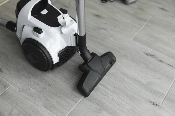 Bagless cyclone vacuum cleaner on a grey tile. Electrical apparatus that by means of suction collects dust and small particles from floors and other surfaces. — Stock Photo, Image