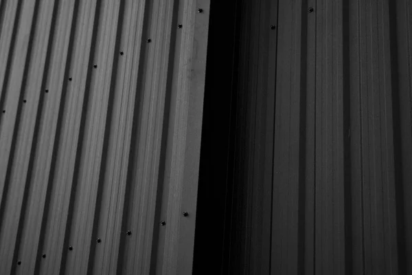 Folha de ferro ondulado preto usado como uma fachada de um armazém ou fábrica. Textura de uma fachada de alumínio de chapa de zinco ondulado sem costura. Arquitetura. Textura metálica. — Fotografia de Stock