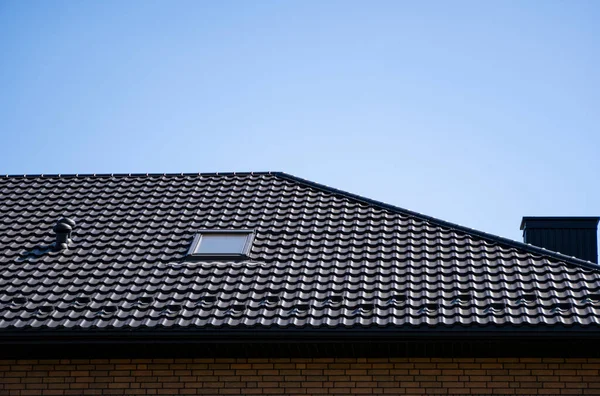 Bruin gegolfd metalen profieldak geïnstalleerd op een modern huis. Het dak van golfplaten. Dakbedekking van metalen profiel golvende vorm. Modern dak van metaal. Metalen dakbedekking. — Stockfoto