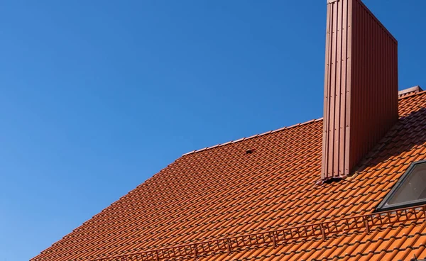 Rood gegolfd metalen profieldak geïnstalleerd op een modern huis. Het dak van golfplaten. Dakbedekking van metalen profiel golvende vorm. Modern dak van metaal. Metalen dakbedekking. — Stockfoto