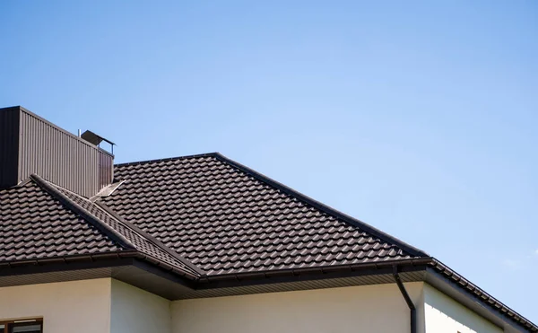 Brun korrugerad metall profil tak installerat på ett modernt hus. Taket på wellpapp. Takläggning av metallprofil vågig form. Modernt tak av metall. Takläggning av metall. — Stockfoto